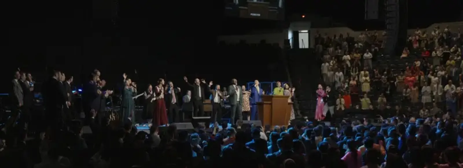Large worship service with stage and sound production supported by Phase 3 Live, congregation standing with raised hands