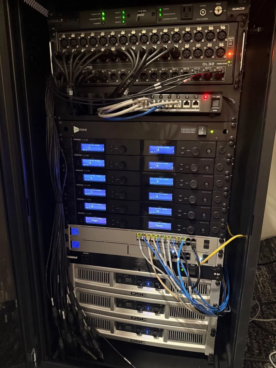 Installed audio equipment rack with digital stage box, wireless receivers, and amplifiers built by Phase 3 Live