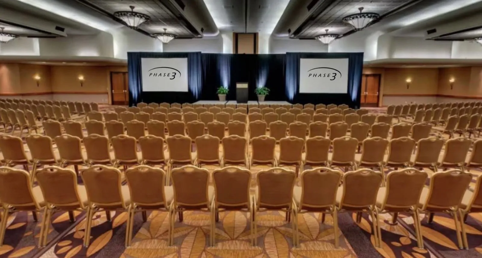 Hotel ballroom general session produced by Phase 3 Live with dual projection screens and pipe and drape