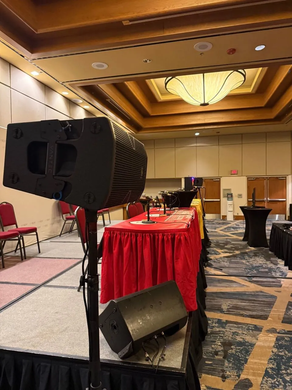 Speaker on a stand and head-table microphones set by Phase 3 Live for a hotel ballroom panel session