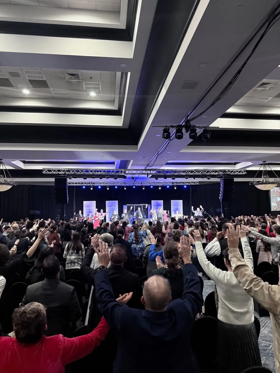 Worship service in a large ballroom with stage lighting and audio production by Phase 3 Live
