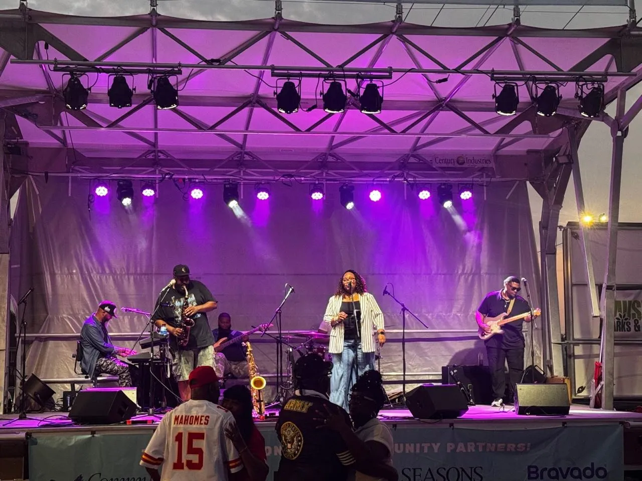 Band performing under a purple lighting wash on a mobile stage at dusk, produced by Phase 3 Live