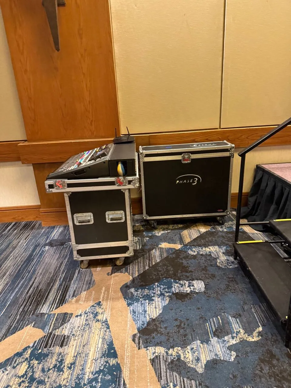 Phase 3 Live branded road case and audio rack staged beside a riser at a hotel conference venue