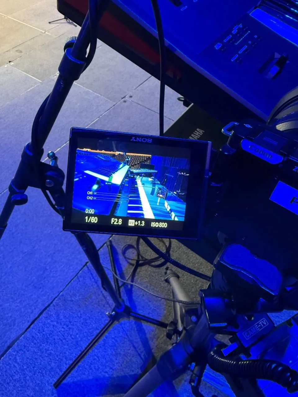 Camera monitor showing a live feed of a keyboard during a blue-lit Phase 3 Live production