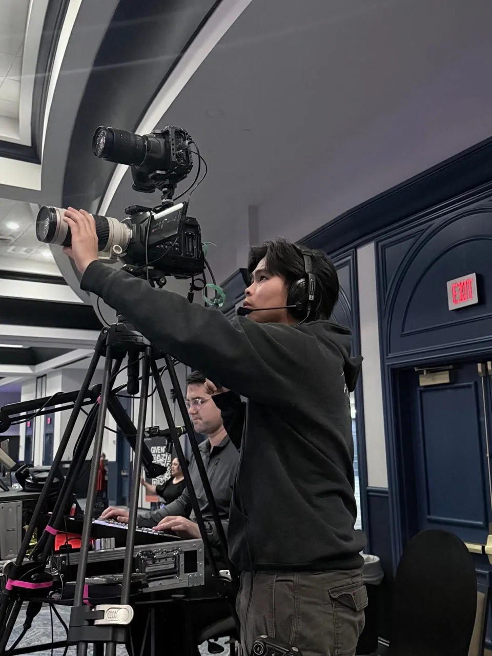 Phase 3 Live camera operator adjusting a cinema camera rig during a live event broadcast