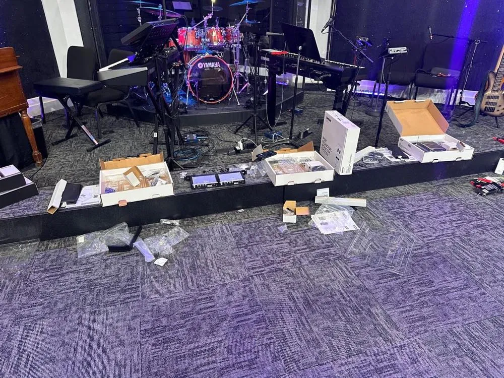 New audio equipment unboxed on a church platform during a Phase 3 Live AV installation.
