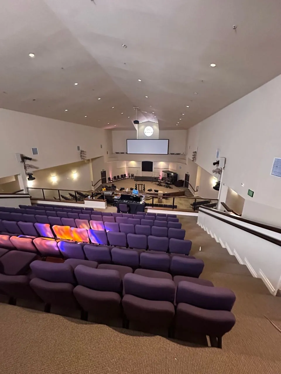 Balcony view of a church sanctuary with purple seating and projection screen ahead of a Phase 3 Live AV upgrade.