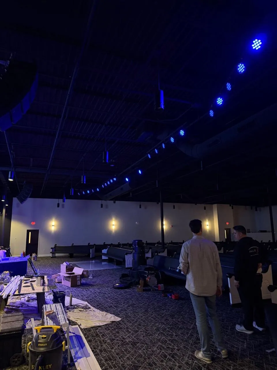 Crew reviewing newly installed blue stage lighting in a church auditorium during a Phase 3 Live AV installation.