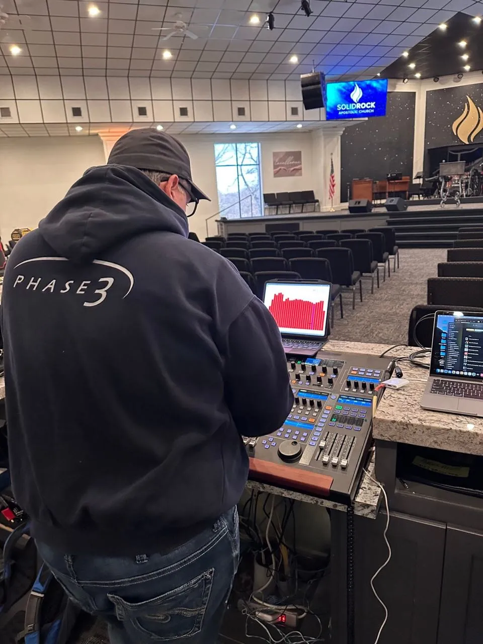 Phase 3 Live engineer mixing church audio on a digital console in a sanctuary