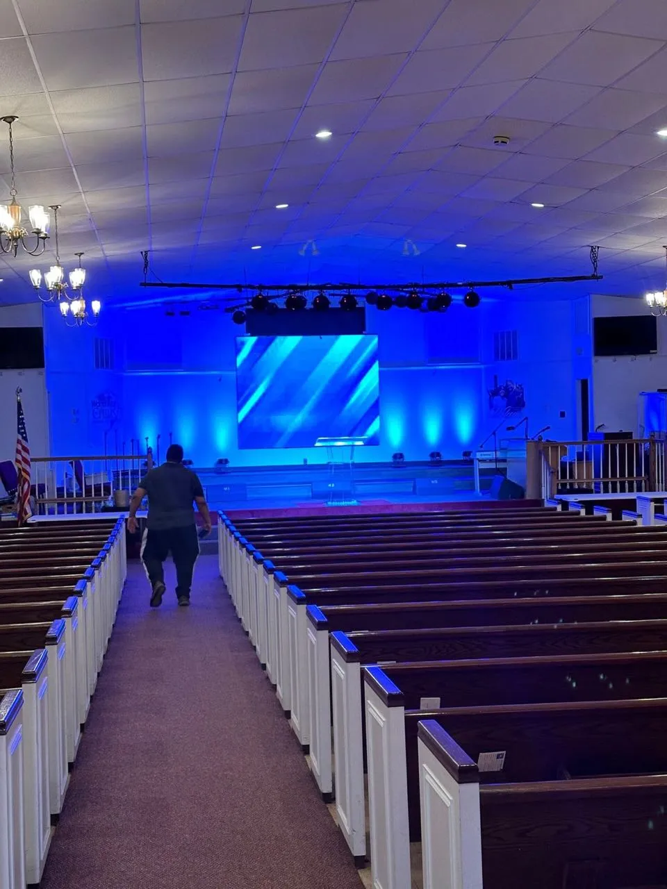 Church sanctuary stage lighting and projection screen installed by Phase 3 Live, lit in deep blue.