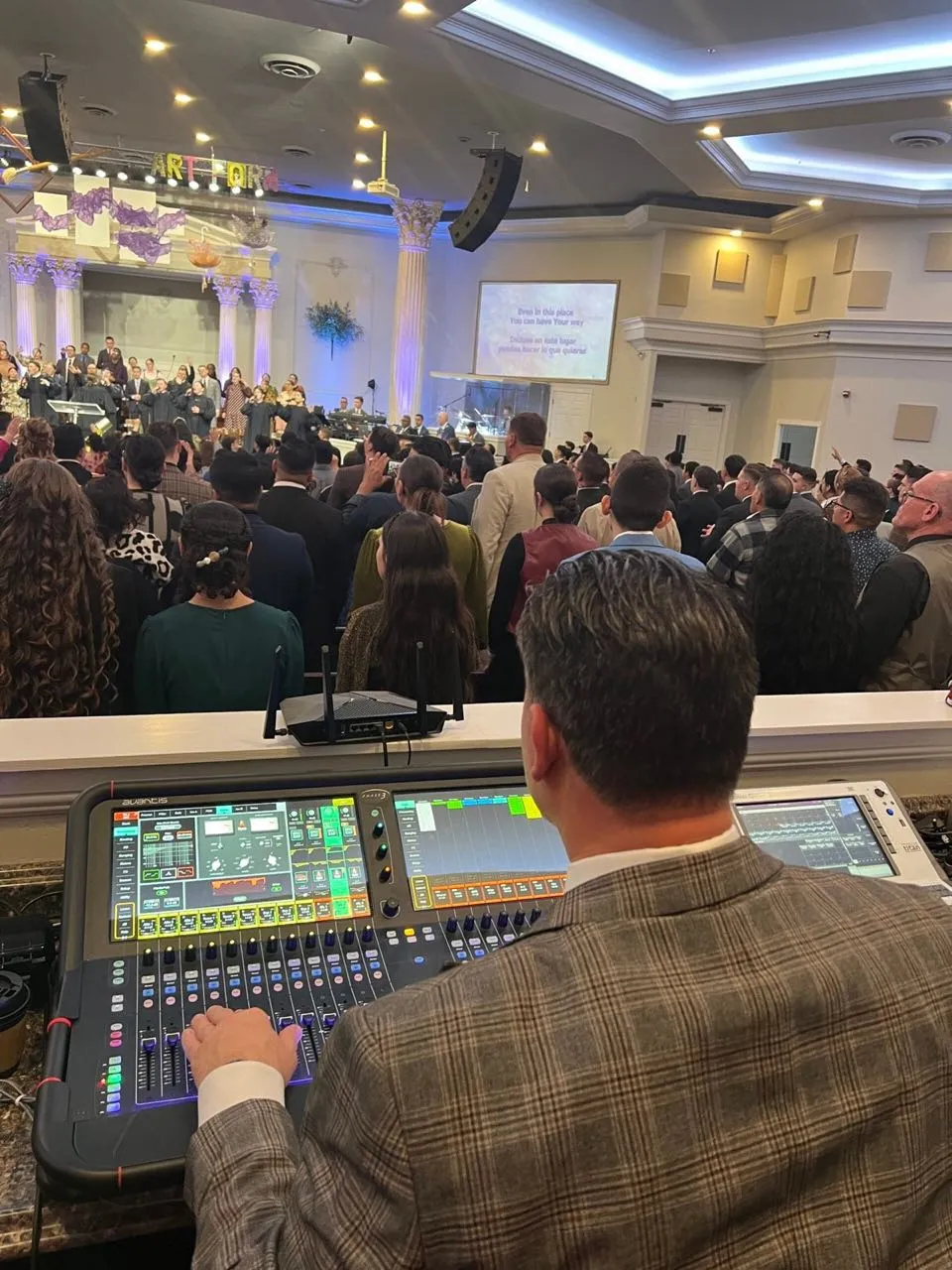 Phase 3 Live sound engineer mixing a worship service in a full church sanctuary