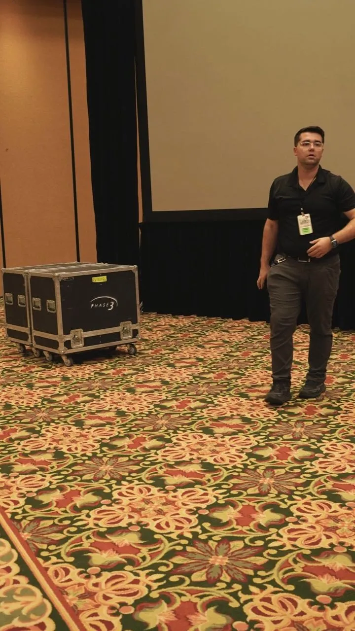 Phase 3 Live crew member with branded road cases during setup at a ballroom event