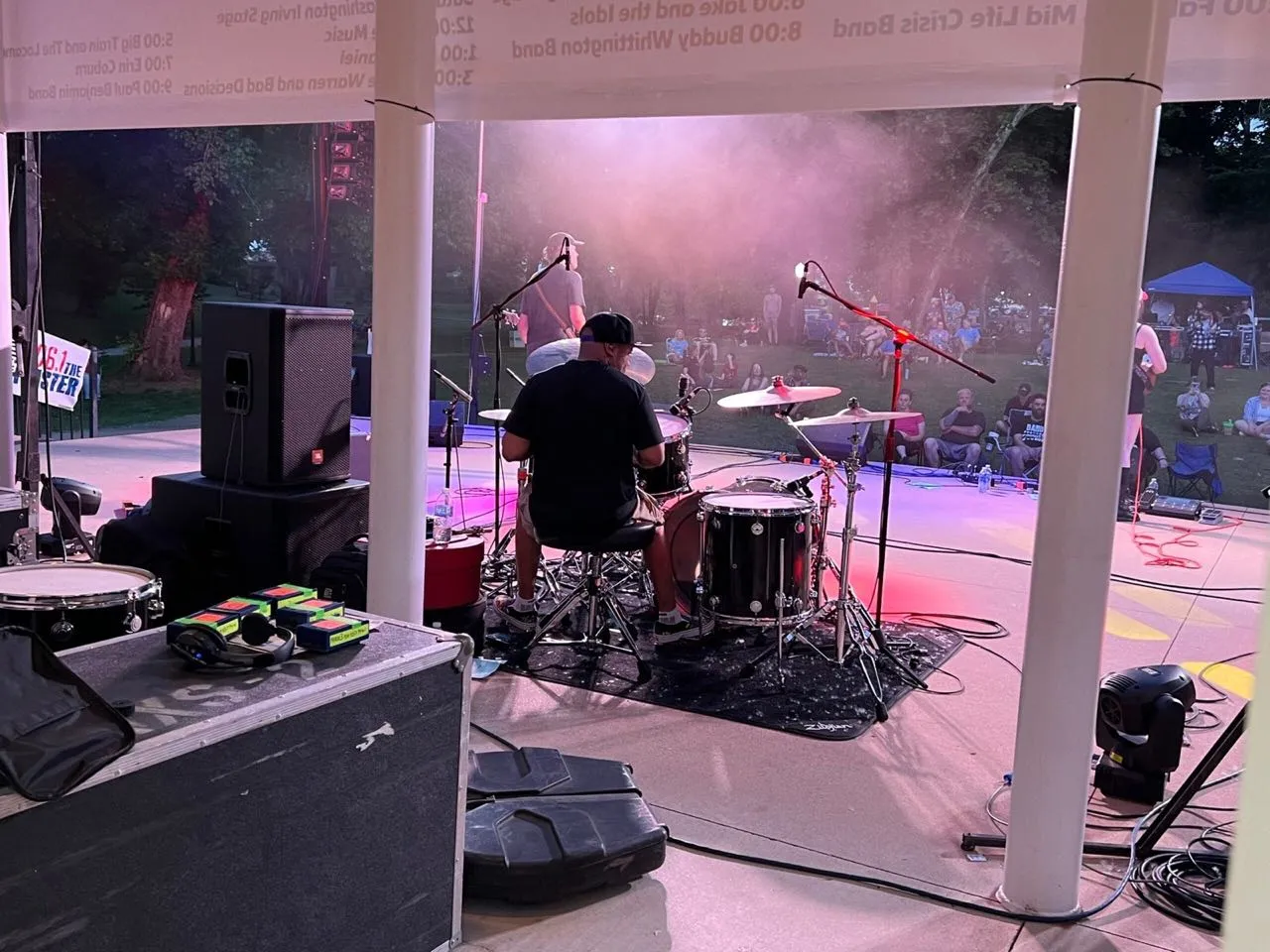 Drummer performing on an outdoor bandshell stage at a community concert with sound and lighting support from Phase 3 Live