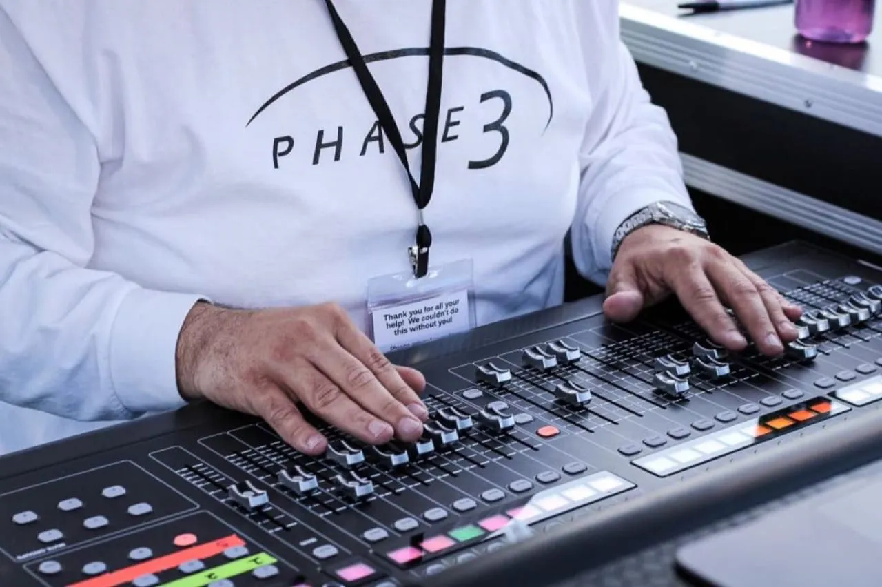 Phase 3 Live audio engineer mixing on a digital console at a live event