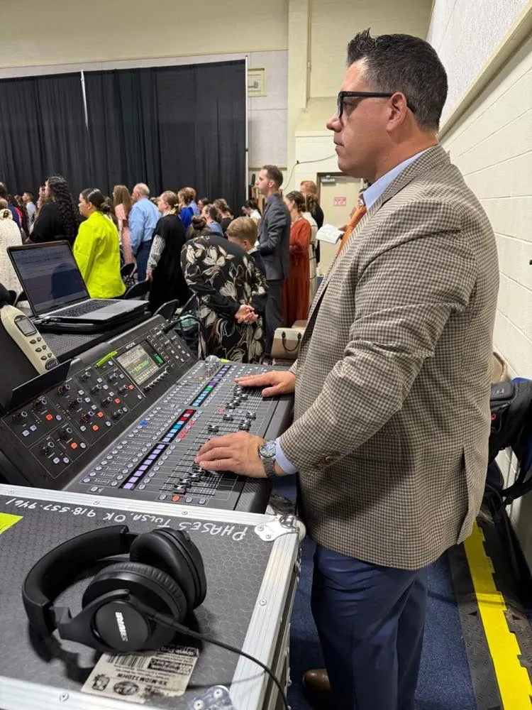 Phase 3 Live sound engineer mixing a worship service from a front-of-house console