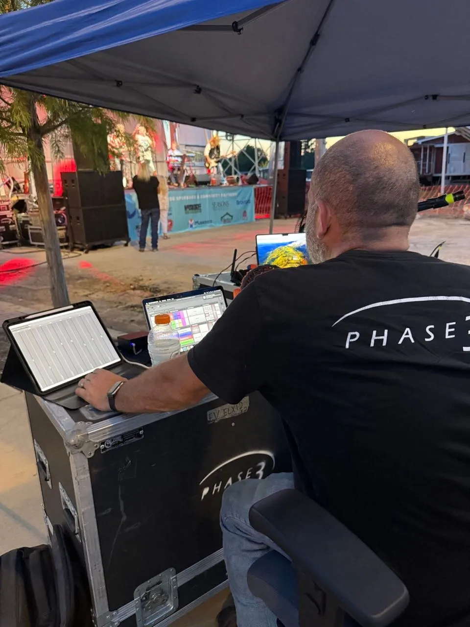 Phase 3 Live engineer mixing an outdoor community concert from the front-of-house tent