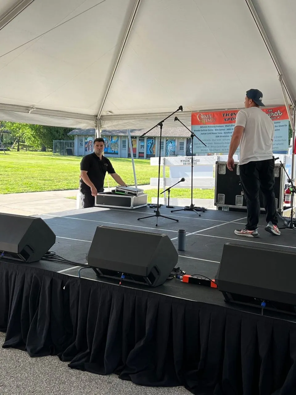 Phase 3 Live crew setting up microphones and equipment on a tented festival stage