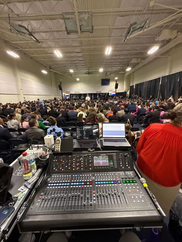 Front-of-house audio console overlooking a packed indoor congregation at a church convention produced by Phase 3 Live