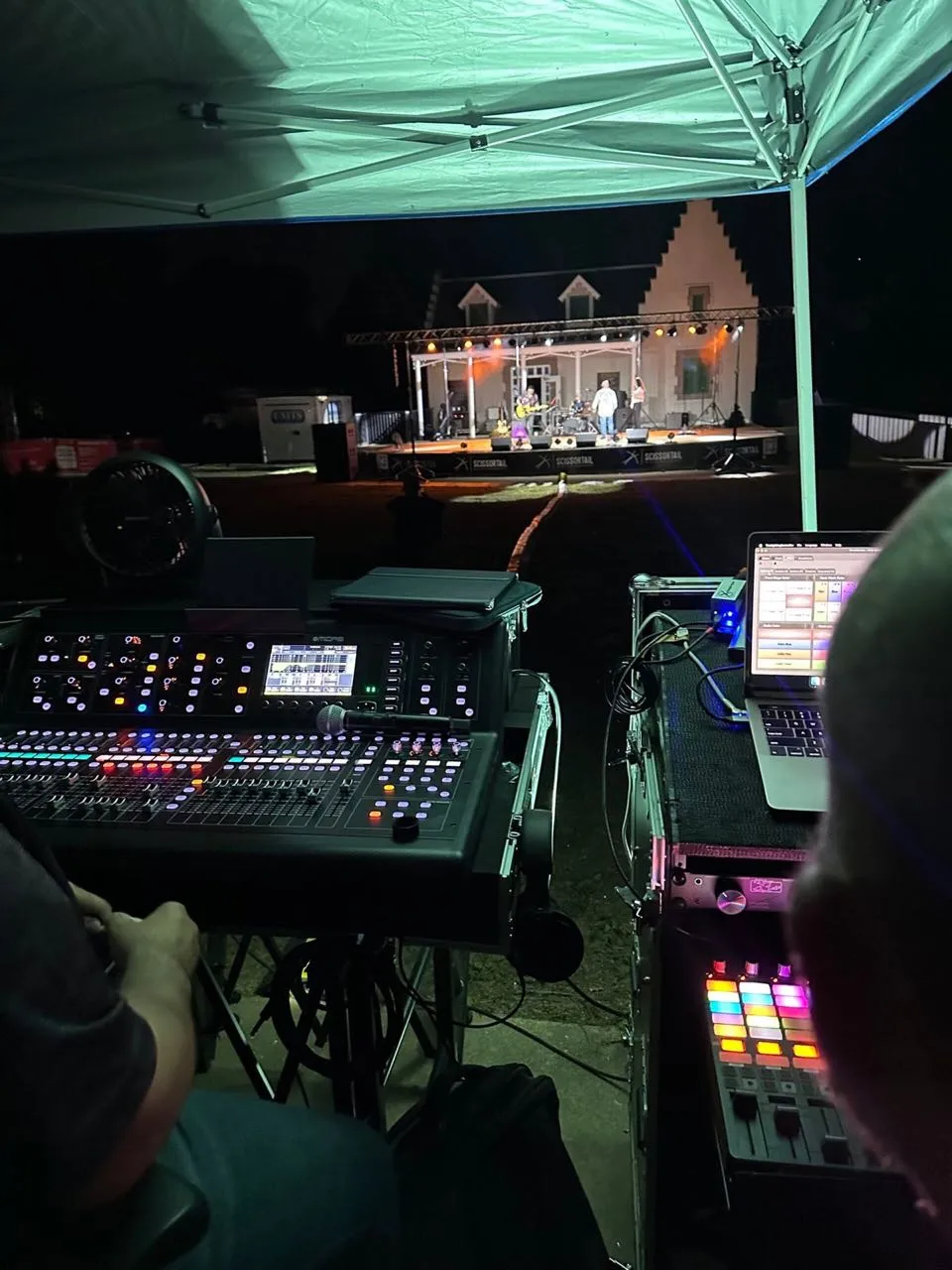 Phase 3 Live front-of-house mixing console and lighting control at a nighttime outdoor concert