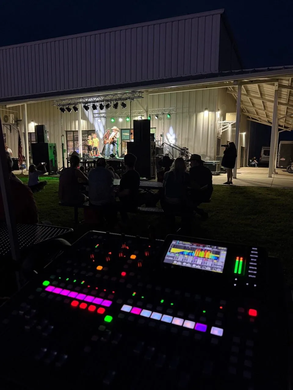Front-of-house console glowing at night during an outdoor country concert produced by Phase 3 Live
