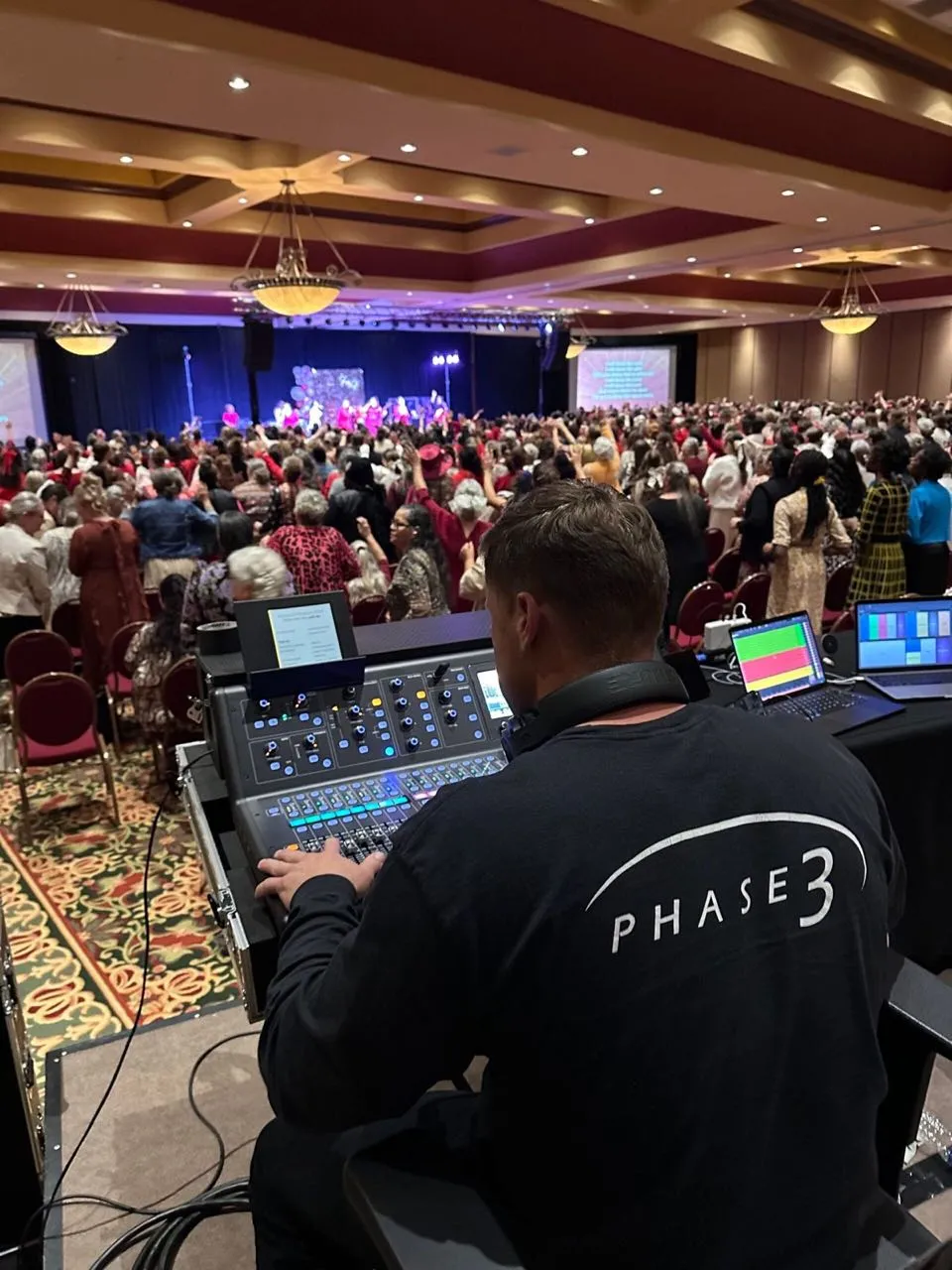 Phase 3 Live engineer mixing front of house for a packed ballroom event.