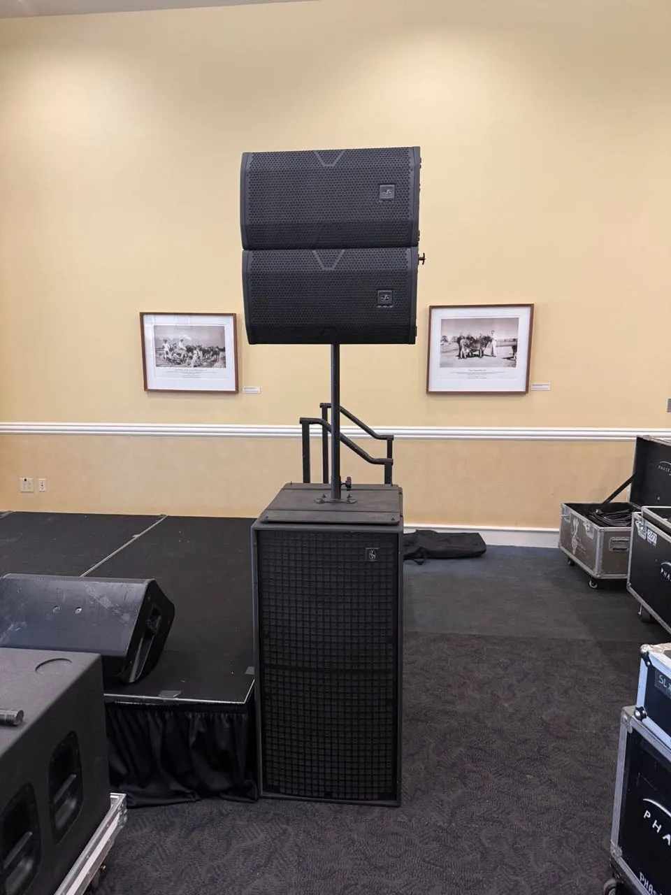 Ground-stacked speakers and subwoofer staged by Phase 3 Live beside a ballroom stage
