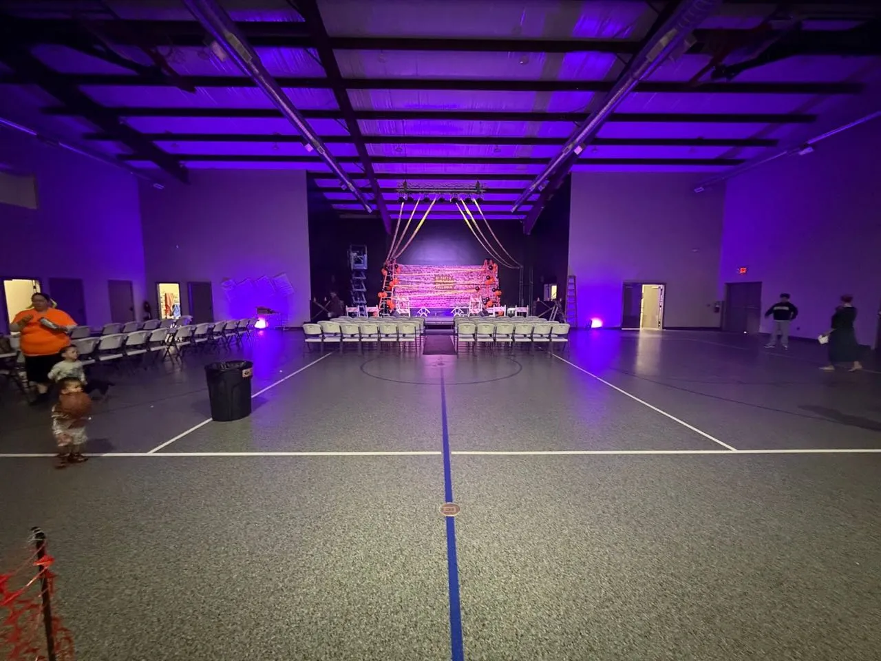 Purple event lighting and staging in a gymnasium set up by Phase 3 Live