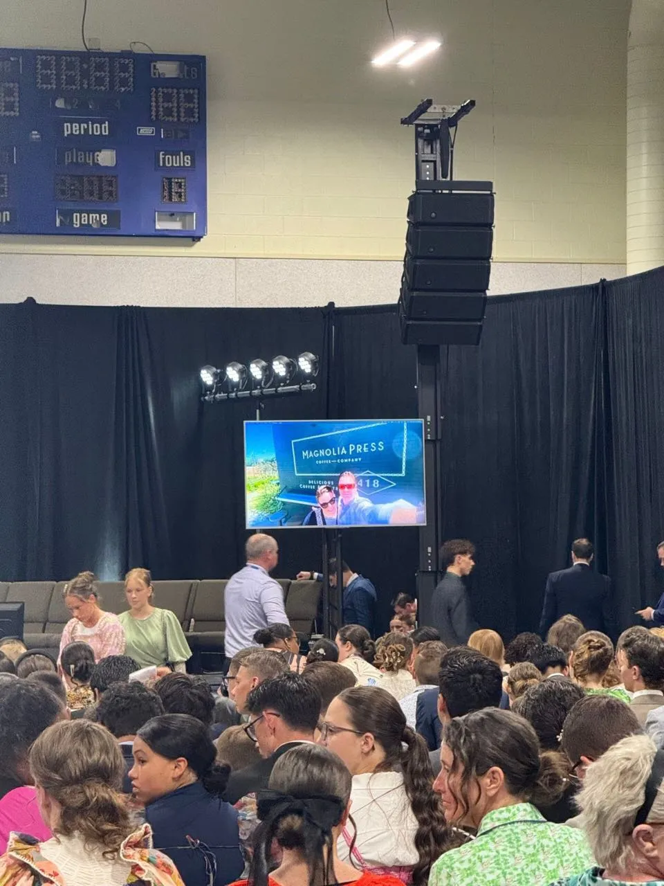 Large audience at an indoor gathering with flown line array sound and screens provided by Phase 3 Live