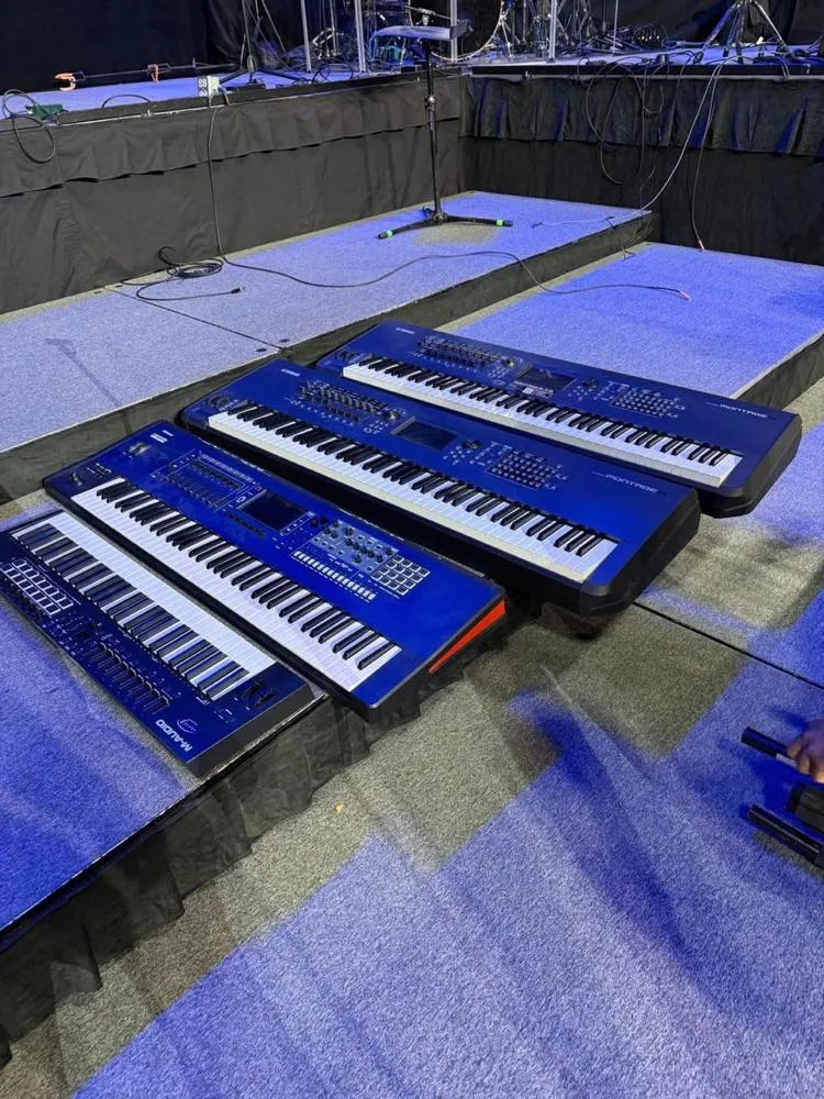 Keyboard rigs staged on rolling risers during a Phase 3 Live stage setup