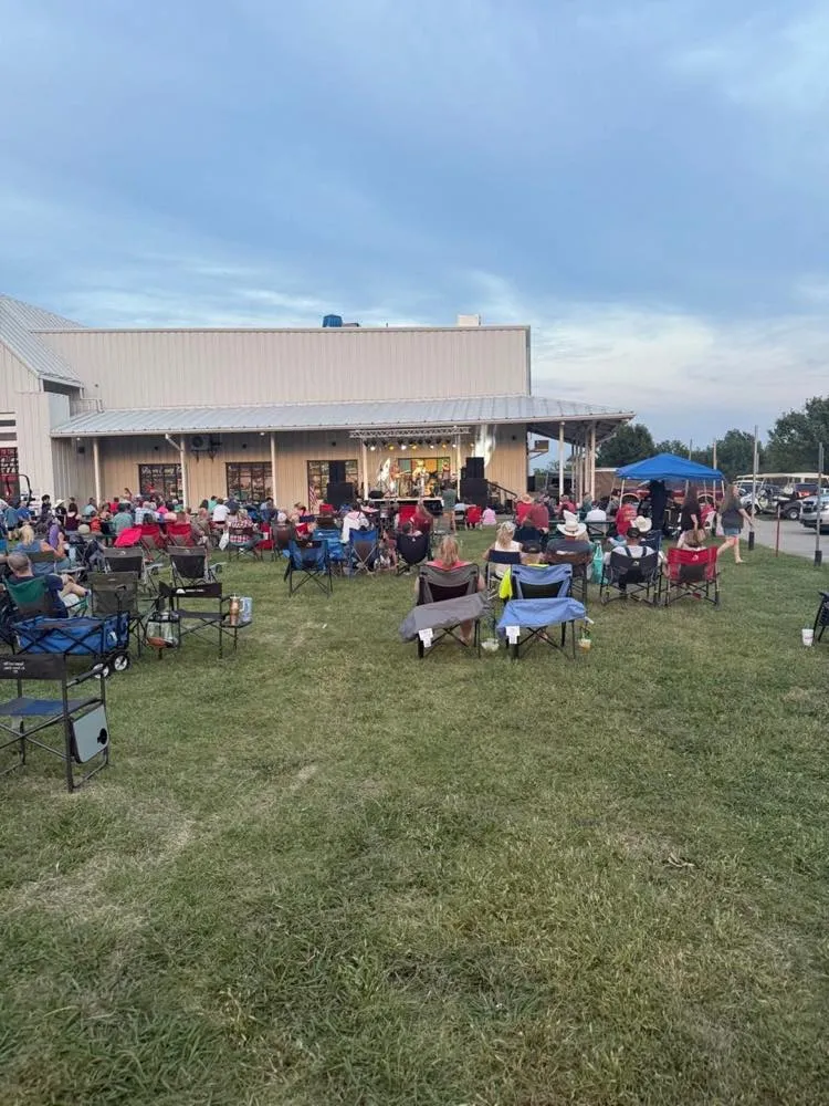 Crowd in lawn chairs at an outdoor evening concert staged by Phase 3 Live