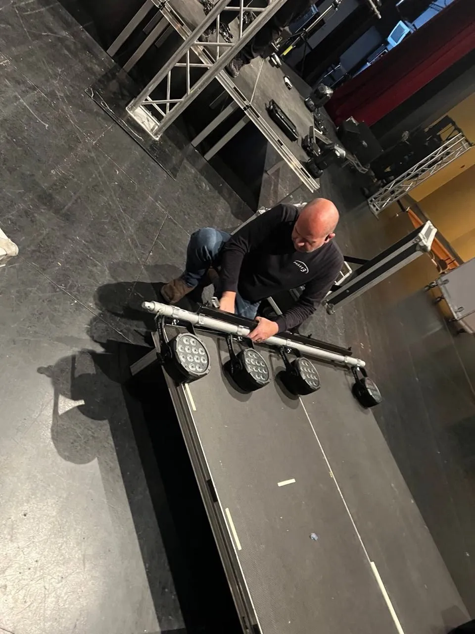 Phase 3 Live technician assembling an LED par light bar during stage setup