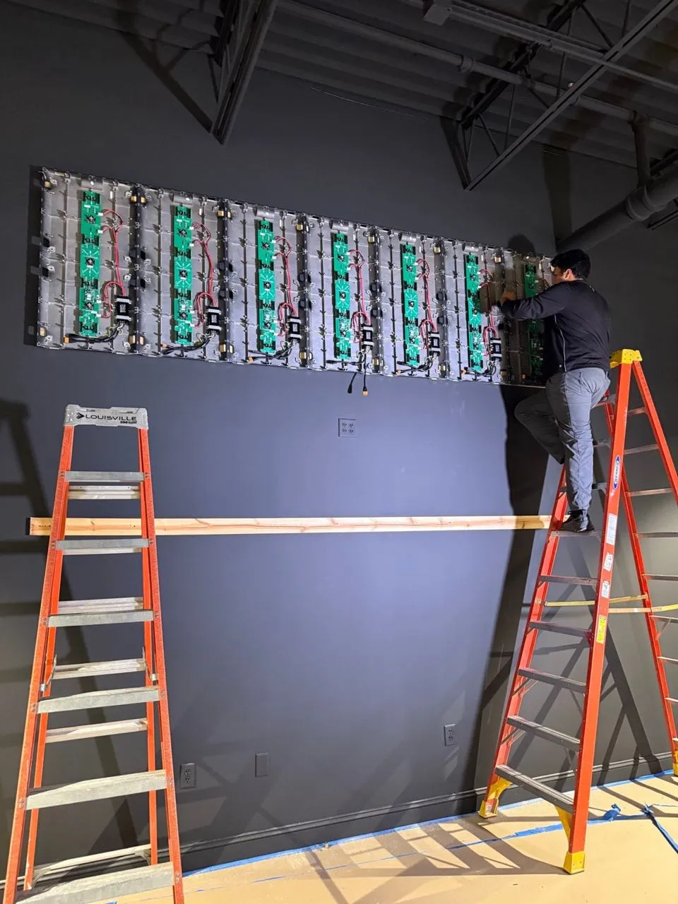 Phase 3 Live technician mounting LED video wall panels during an installation.