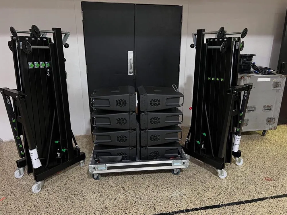 Line-array speaker cabinets and crank lift towers from Phase 3 Live's rental inventory staged on road cases