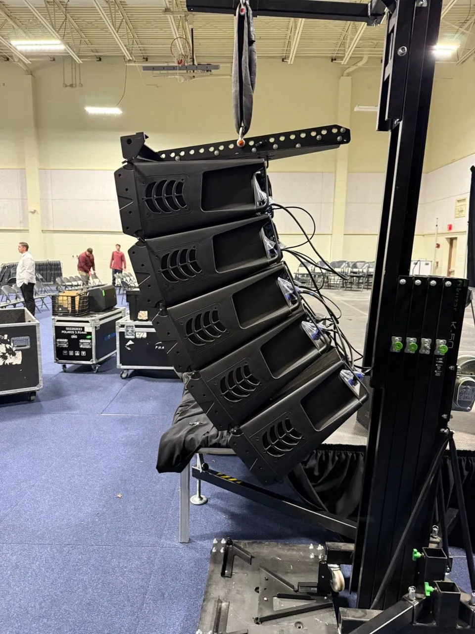 Line array speakers flown from a crank-up tower rig at an indoor event by Phase 3 Live
