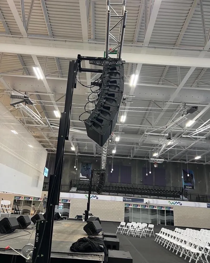 Phase 3 Live line-array speakers rigged on a lift tower during event setup inside an arena