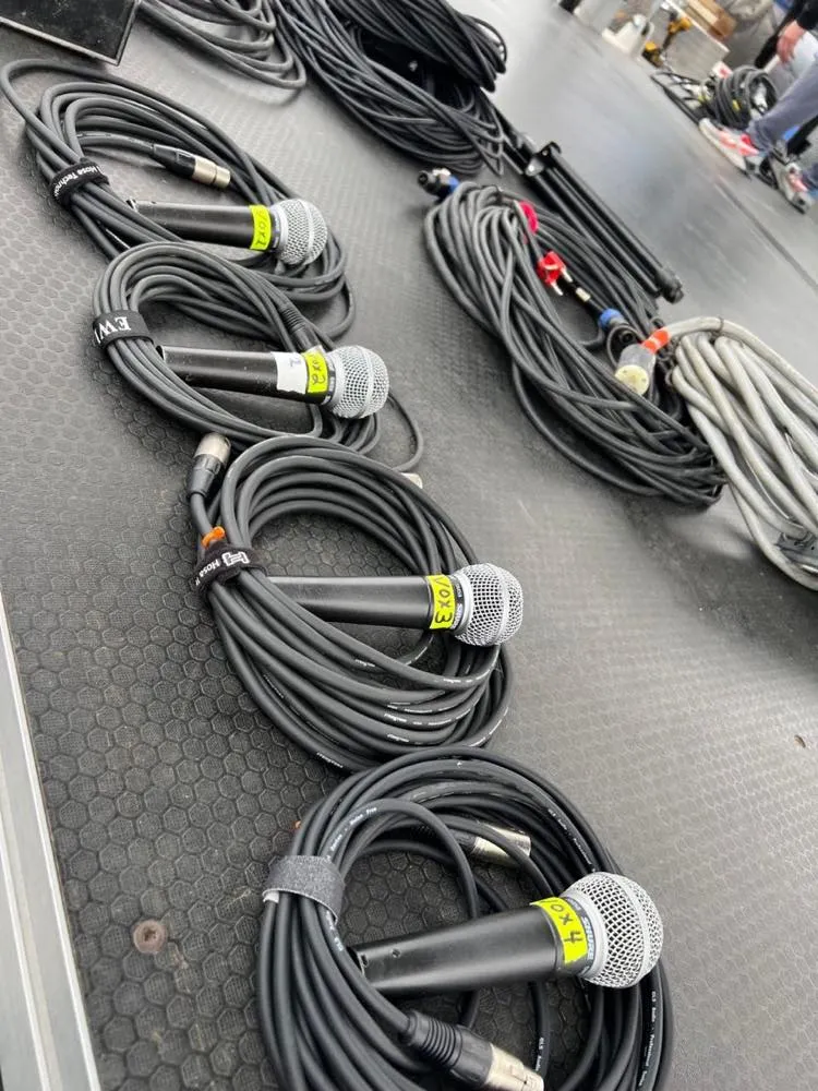 Vocal microphones and coiled XLR cables prepped by Phase 3 Live during stage setup