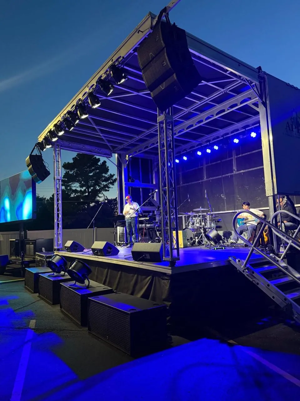 Mobile stage at dusk with LED screen and truss lighting deployed by Phase 3 Live