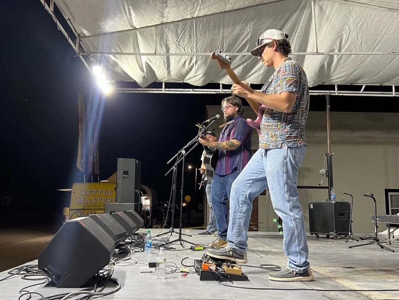 Musicians performing at night on a covered stage with sound reinforcement by Phase 3 Live