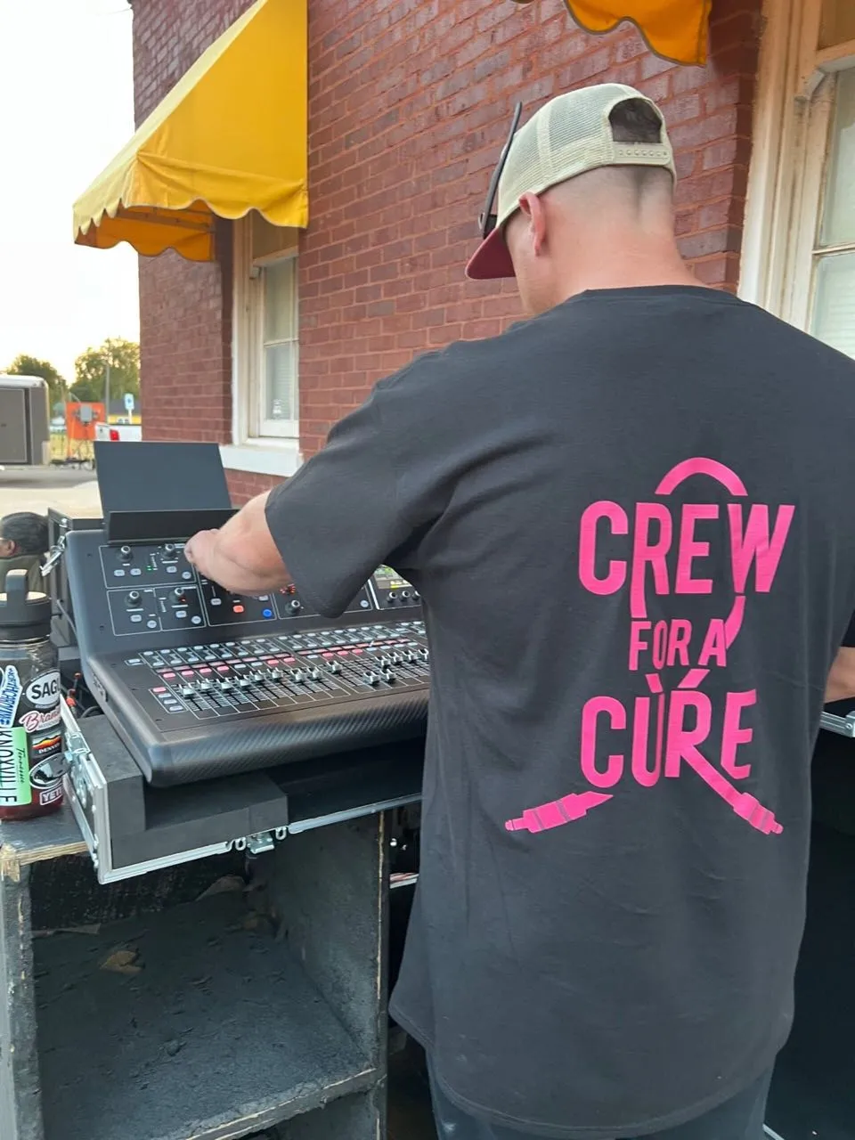 Audio engineer mixing on a digital console at an outdoor event with sound support by Phase 3 Live