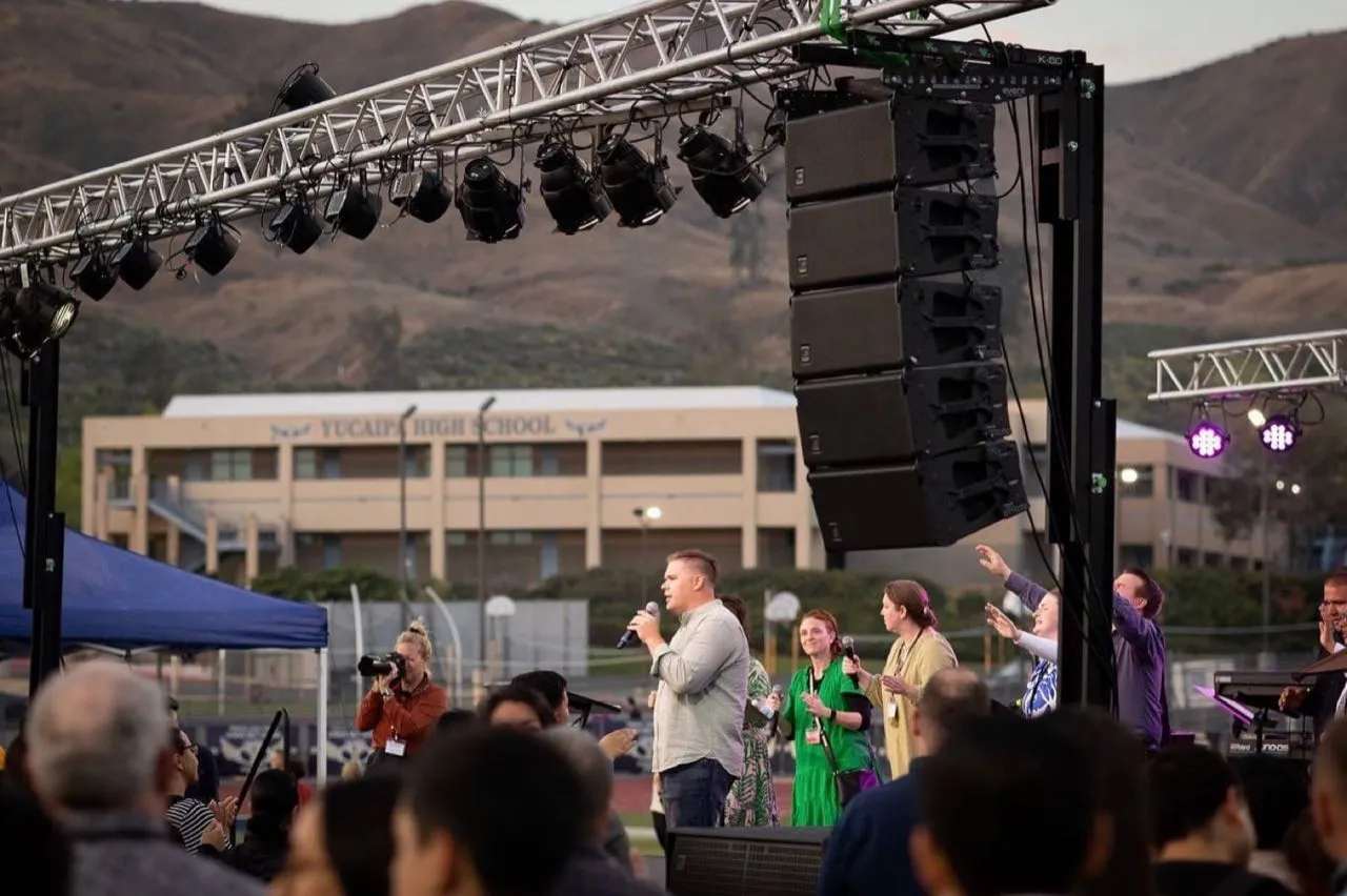 Worship singers under a Phase 3 Live line array and lighting truss at an outdoor event at Yucaipa High School