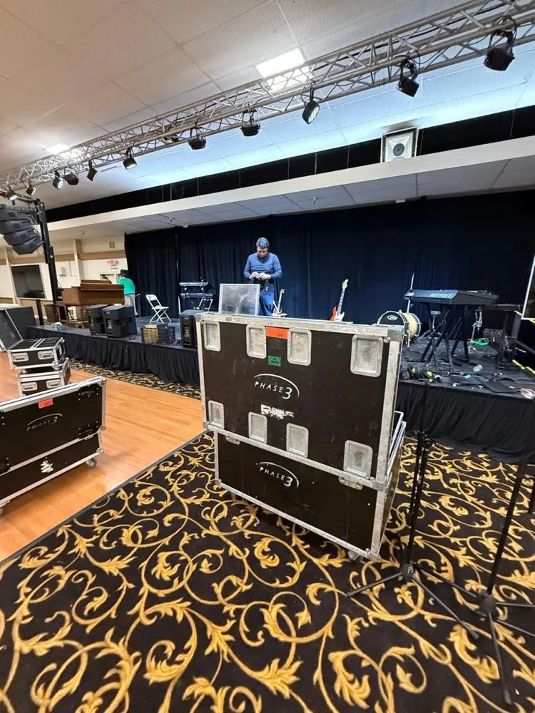 Phase 3 Live road cases in a ballroom during stage and backline setup for an indoor event