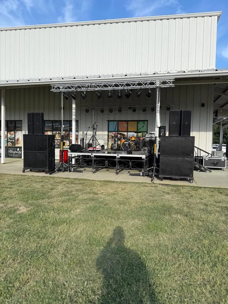 Portable stage, lighting truss, and PA system set up outdoors by Phase 3 Live