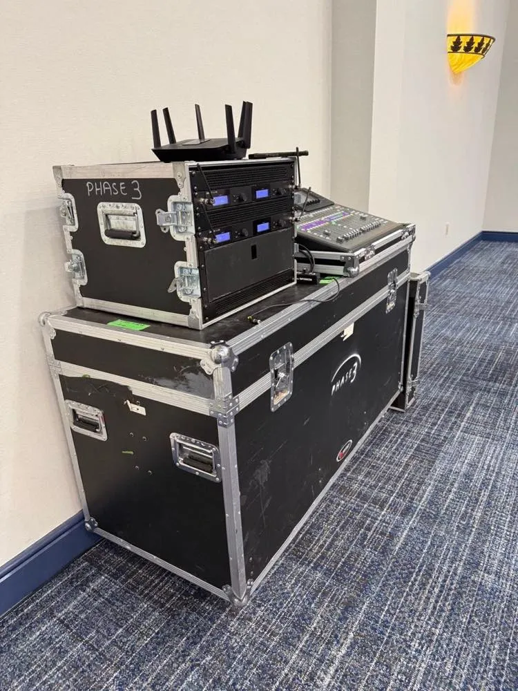 Phase 3 Live road case rig with wireless audio receivers and mixing console staged in a hotel corridor.