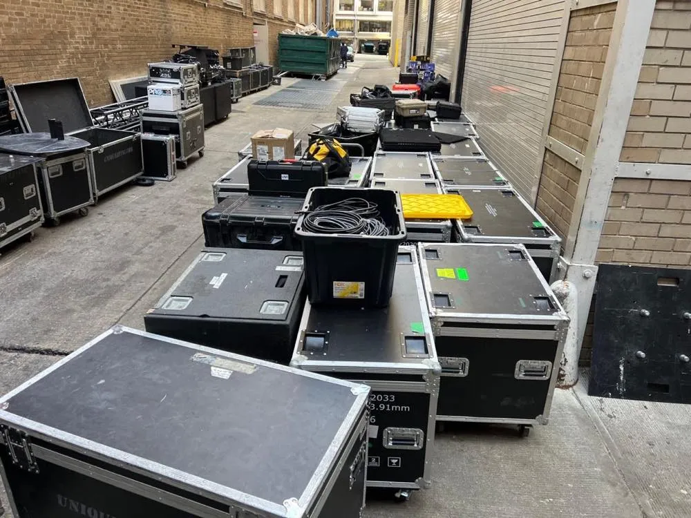 Road cases of Phase 3 Live production equipment staged at a venue loading dock