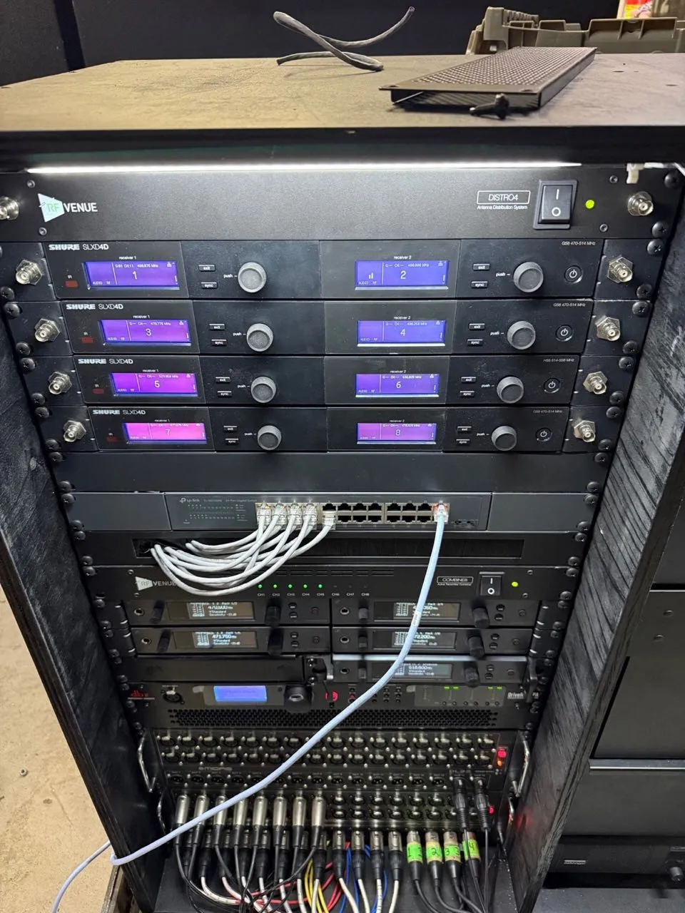 Rack of Shure wireless microphone receivers and networked audio gear from the Phase 3 Live rental inventory.