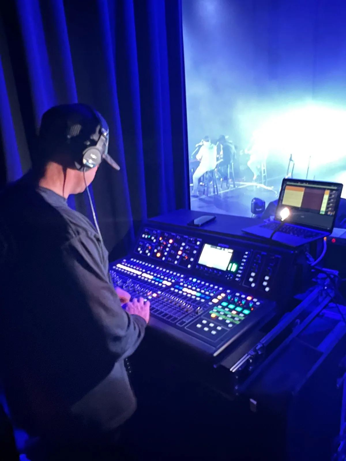 Phase 3 Live engineer mixing from side stage on a digital console during a live show