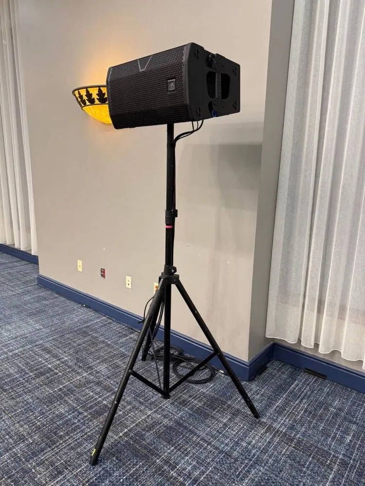 Powered loudspeaker on a tripod stand set up by Phase 3 Live in a hotel meeting room.