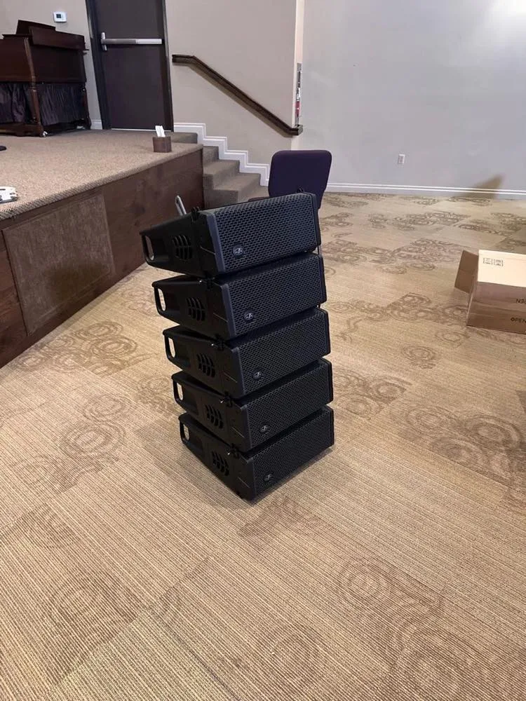Stack of line array speaker cabinets staged for installation in a church by Phase 3 Live.