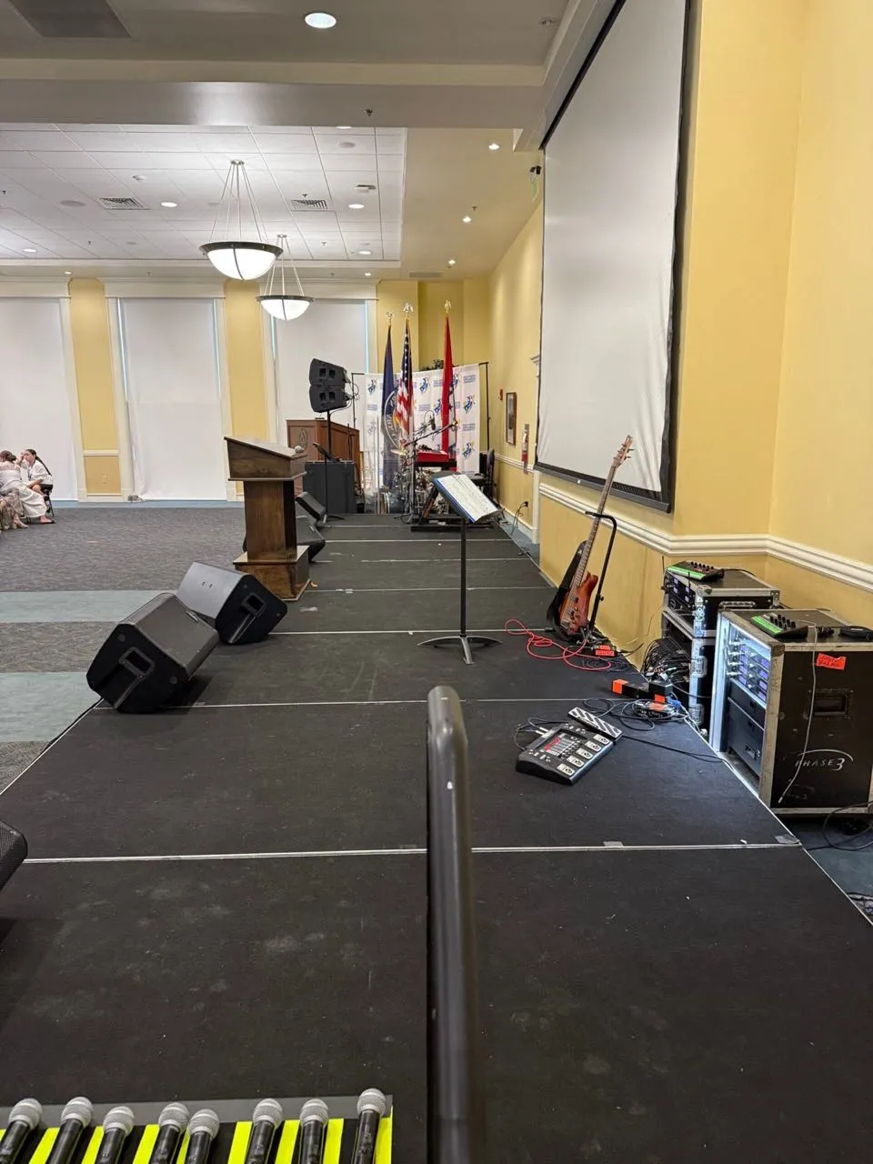Ballroom stage with podium, flags, and backline prepared by Phase 3 Live