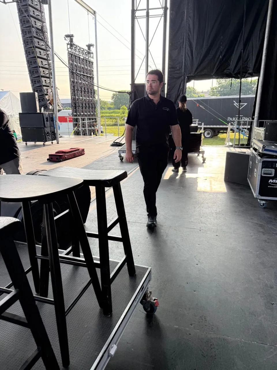 Phase 3 Live technician walking an outdoor stage deck during event setup
